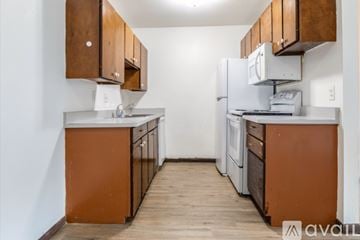 Madison apartment for rent - A kitchen with wooden cabinets and a white refrigerator.