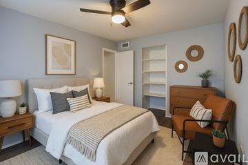 Dallas apartment for rent - A living room with a brown couch, a blue rug, and a painting on the wall.