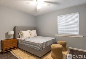 Dallas apartment for rent - A bedroom with a bed, nightstand, and window with blinds.
