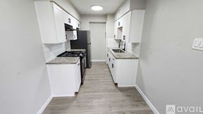 Dallas apartment for rent - A kitchen with white cabinets and a black stove top oven.