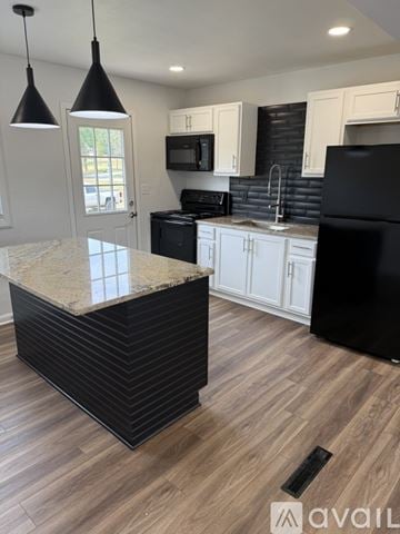Johnstown apartment for rent - A kitchen with a black refrigerator and white cabinets.