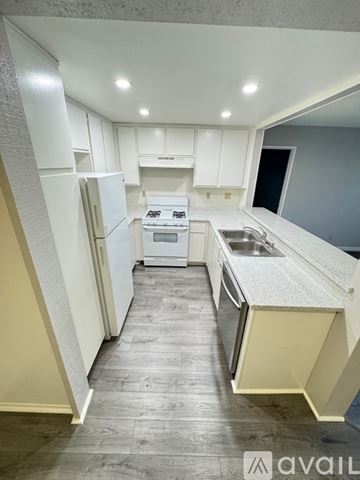 Azusa apartment for rent - A kitchen with white cabinets and a white fridge.