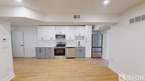 Washington apartment for rent - A kitchen with white cabinets and a wooden floor.