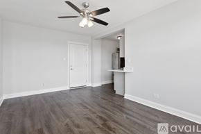 Chicago apartment for rent - A room with a ceiling fan and wooden flooring.