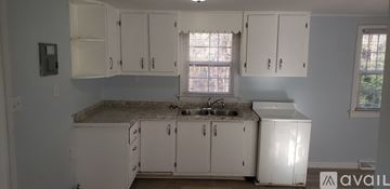 Greensboro house for rent - A kitchen with white cabinets and a granite countertop.