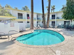 Phoenix apartment for rent - A pool surrounded by palm trees and chairs.