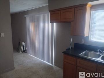 Fullerton apartment for rent - A kitchen with wooden cabinets and a black countertop.