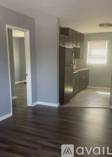 Wheaton apartment for rent - A kitchen with dark wood floors and white walls.