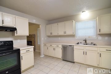 Killeen house for rent - A kitchen with white cabinets and a black stove top oven.