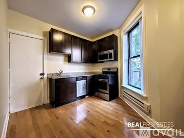 Chicago apartment for rent - A kitchen with dark brown cabinets and a white door.