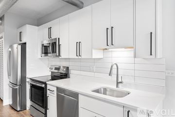 Chicago apartment for rent - A modern kitchen with white cabinets and stainless steel appliances.