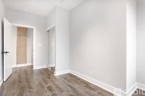 Chicago apartment for rent - A room with white walls and wooden flooring with a door on the left.