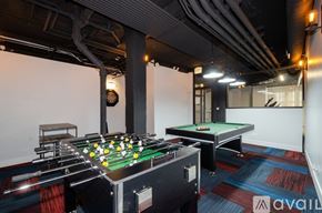 Chicago apartment for rent - A pool table with a green felt cloth and white balls is in the foreground of the image.