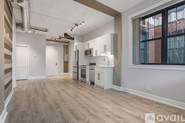 Chicago apartment for rent - A spacious kitchen with white cabinets and a window overlooking a brick building.