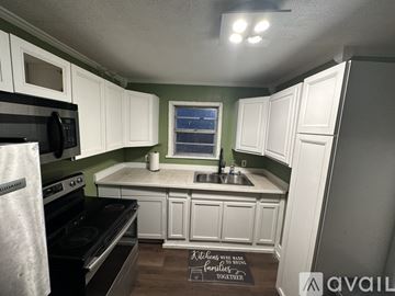 Jackson house for rent - A kitchen with white cabinets and a black stove top oven.