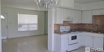 Miami Gardens house for rent - A kitchen with white cabinets and a tiled floor.