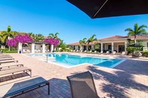 Miami Lakes apartment for rent - a swimming pool with lounge chairs and a building in the background