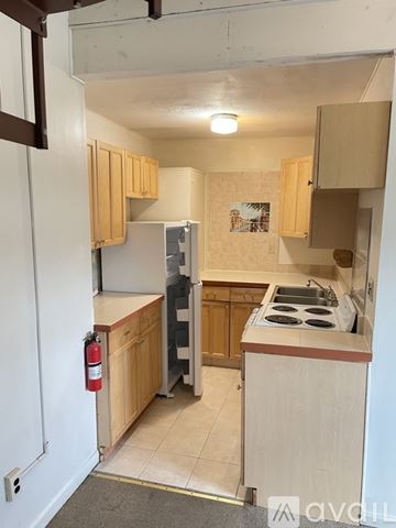 Poultney apartment for rent - A kitchen with wooden cabinets and a stove top oven.