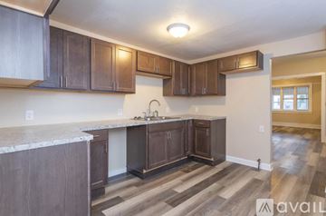 Grand Rapids house for rent - A kitchen with brown cabinets and a marble countertop.