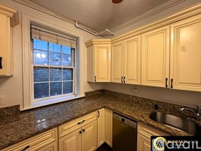 Brookline apartment for rent - A bedroom with a white bed and a green cabinet.