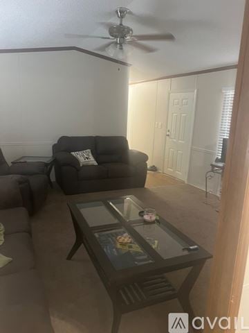 Denham Springs apartment for rent - A living room with a grey couch and a glass coffee table.
