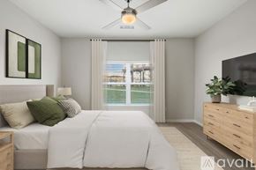 New Braunfels apartment for rent - A bedroom with a large bed, a ceiling fan, and a window with blinds.