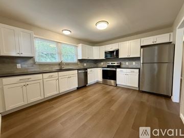 Groton house for rent - A kitchen with white cabinets and stainless steel appliances.