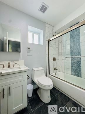 Los Angeles townhouse for rent - A white bathroom with a toilet, sink, and mirror.
