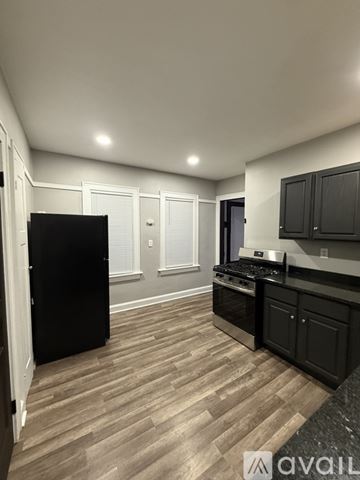 Milwaukee apartment for rent - A kitchen with black cabinets and a black refrigerator.