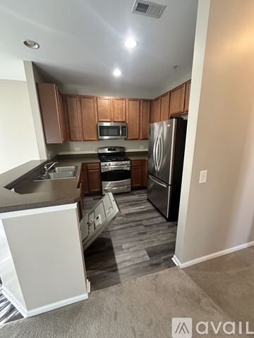 Pingree Grove condo for rent - A kitchen with wooden cabinets and a black refrigerator.