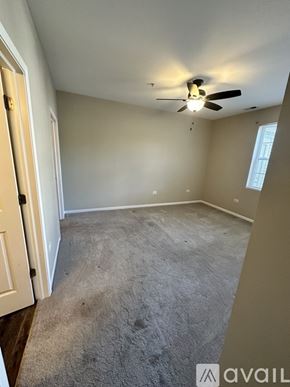Pingree Grove condo for rent - A room with a ceiling fan and carpeted floor.