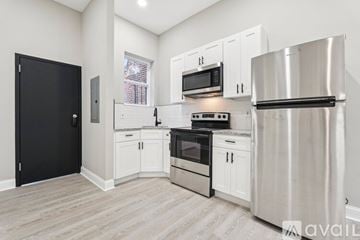 Baltimore apartment for rent - A kitchen with white cabinets and stainless steel appliances.
