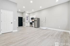 Baltimore apartment for rent - A spacious kitchen with white cabinets and a black refrigerator.