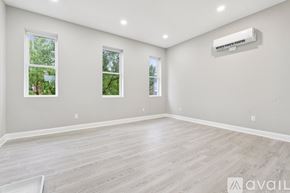 Baltimore apartment for rent - A spacious room with a light-colored floor and two windows.