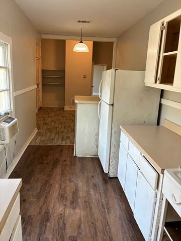 Mobile house for rent - A kitchen with white cabinets and a wooden floor.