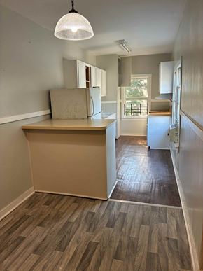 Mobile house for rent - A room with a wooden floor and a light hanging from the ceiling.