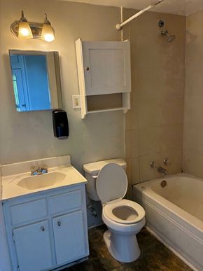 Mobile house for rent - A white bathroom with a toilet, sink, and bathtub.