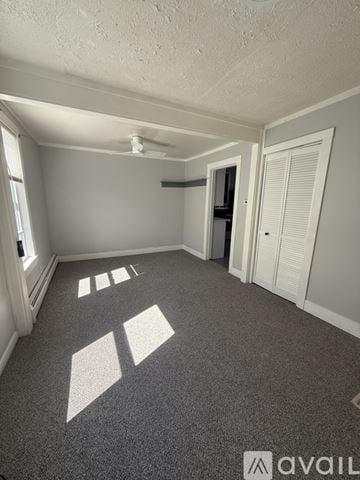 Biddeford apartment for rent - A kitchen with white cabinets and a black stove top oven.