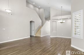 Scottsdale house for rent - A spacious room with wooden flooring and a staircase.