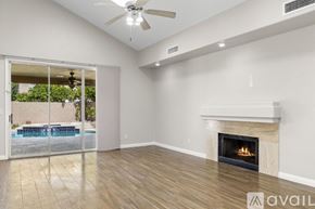 Scottsdale house for rent - A spacious room with a fireplace and sliding glass doors leading to a pool area.