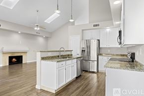 Scottsdale house for rent - A modern kitchen with white cabinets and a fireplace.