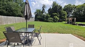 Charlotte apartment for rent - A patio table with chairs and an umbrella is set up on a concrete slab.