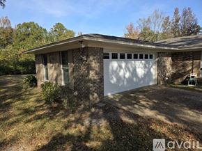 Atmore house for rent - A house with a white picket fence and a small garden.