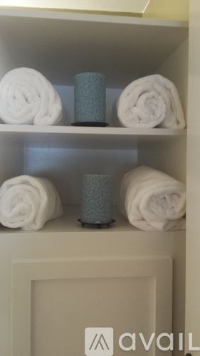 Cody house for rent - A shelf with towels and candles on it.
