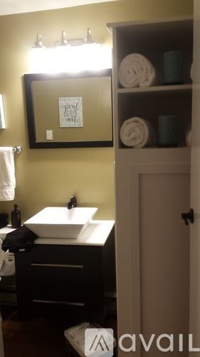 Cody house for rent - A bathroom with a sink, mirror, and towel rack.