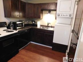 Cody house for rent - A kitchen with a black stove top oven and a white refrigerator.