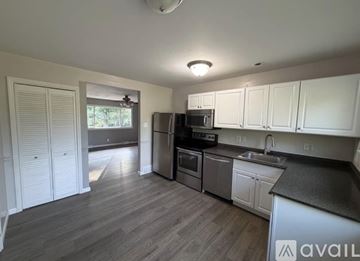 Arnold house for rent - A kitchen with white cabinets and a black countertop.