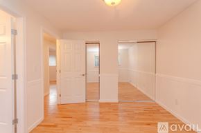 Auburn apartment for rent - A spacious room with wooden floors and white walls.