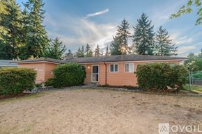 Auburn apartment for rent - A house with a brown roof and a brown fence is surrounded by green trees.