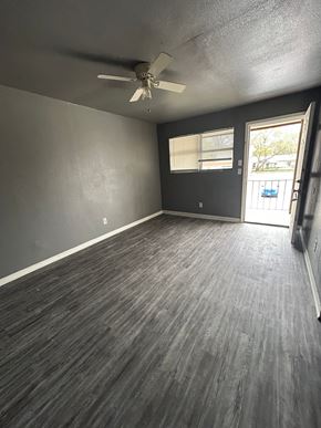 Killeen apartment for rent - A room with a ceiling fan and a door leading outside.